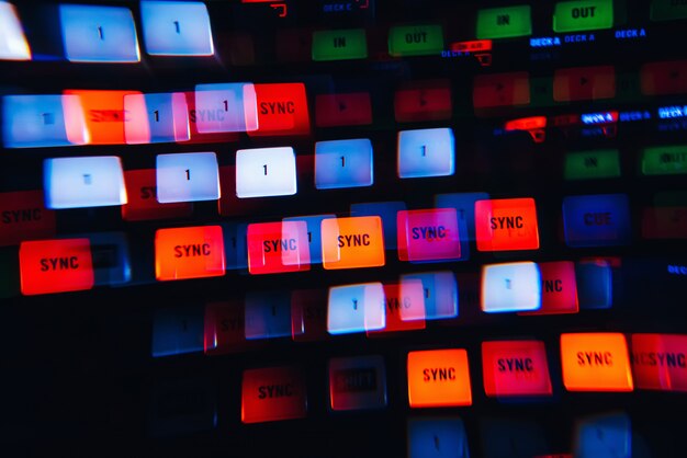 DJ mixer in a nightclub with a background of glowing lights from buttons