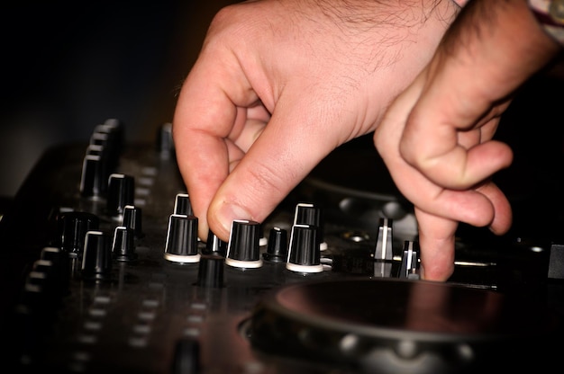 Dj mixes the track in nightclub at party