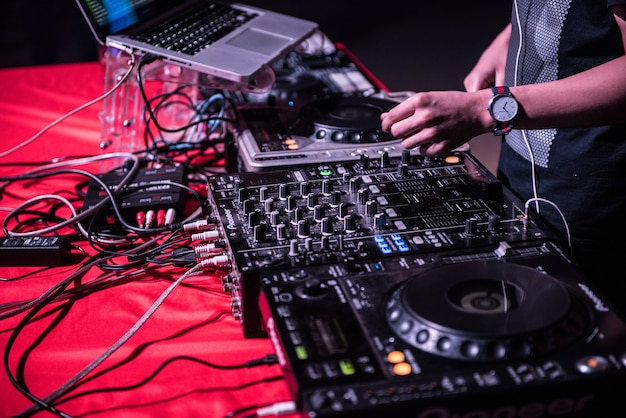 DJ mixt het nummer in de nachtclub op feestje, met de hand muziek op draaischijf op feestje