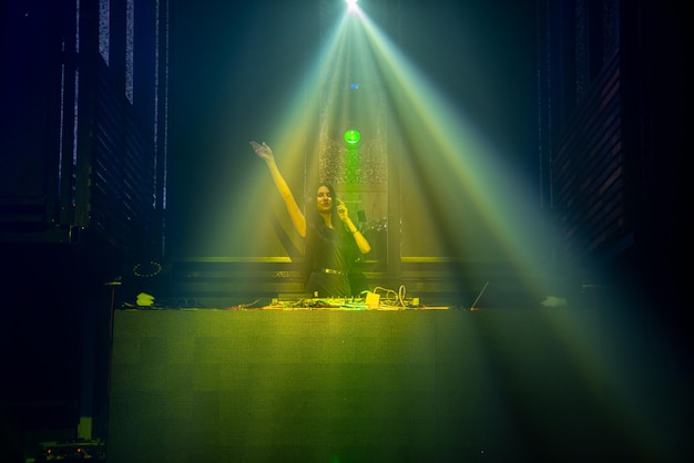 DJ op het podium in een disco-nachtclub die technomuziek beat