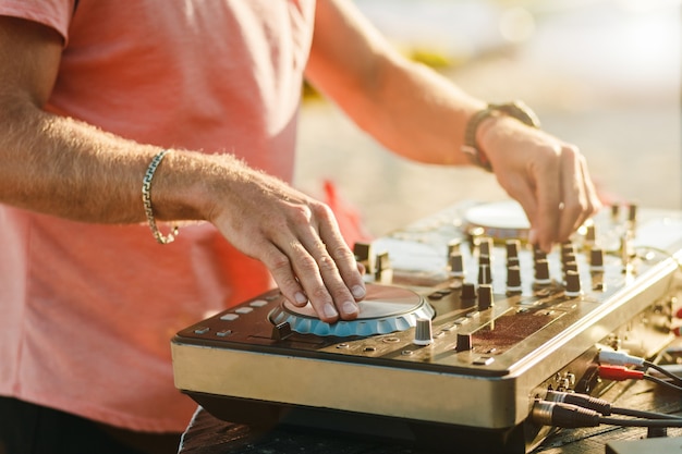 DJ playing at a summer party on dj console