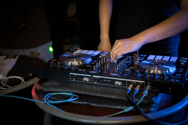 DJ playing turntable music on night club party