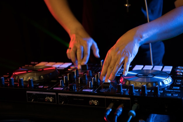 DJ playing turntable music on night club party