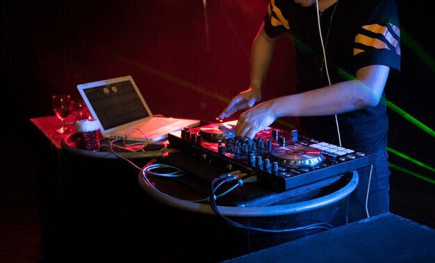 DJ playing turntable music on night club party
