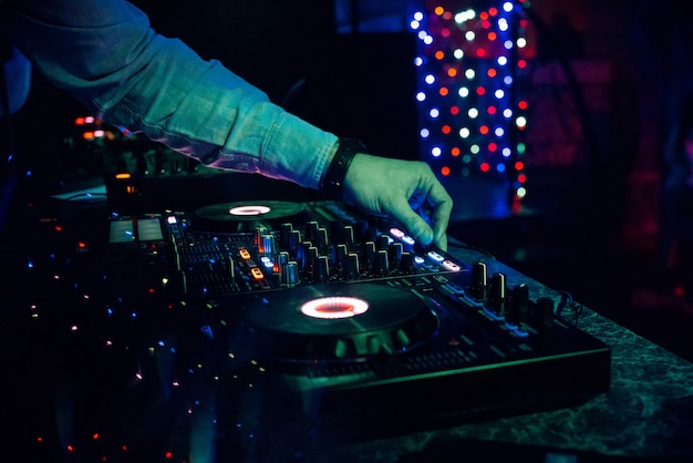 DJ plays electronic music in a nightclub at a party