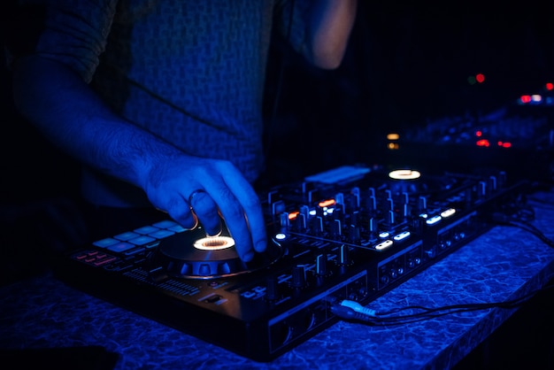 DJ plays electronic music in a nightclub at a party