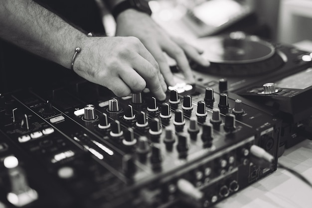 A DJ plays music on a controller at a party