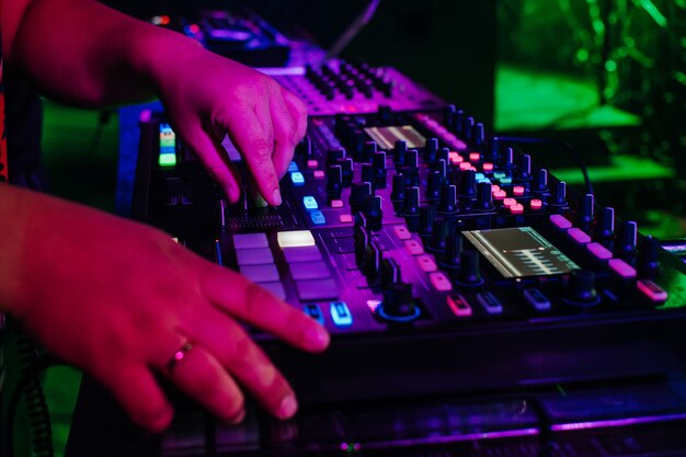 DJ plays music on professional music equipment controller mixer