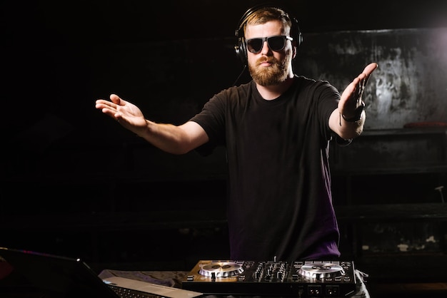 DJ speelt op een mixer in de club op zwarte achtergrond