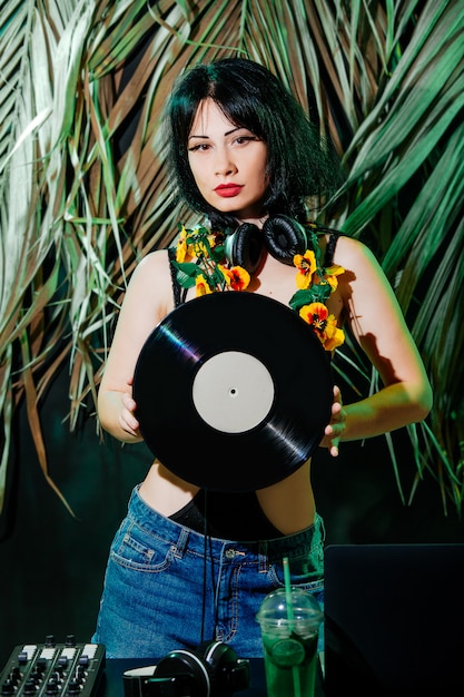 Dj with headphones, black hair and vinyl disk