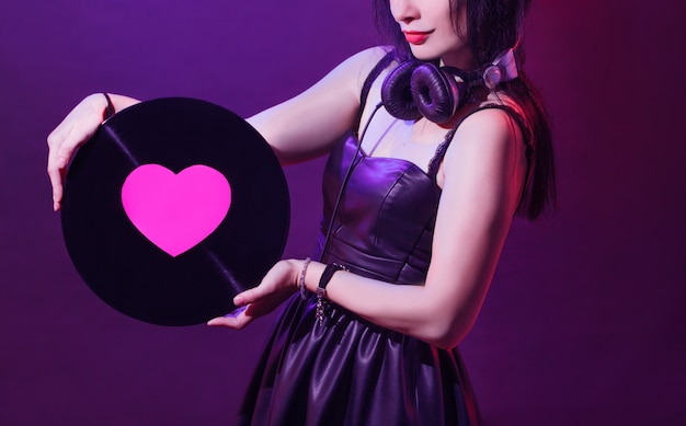 Dj with headphones and pink heart on vinyl disk