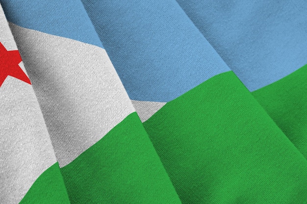 Djibouti flag with big folds waving close up under the studio light indoors The official symbols and colors in banner