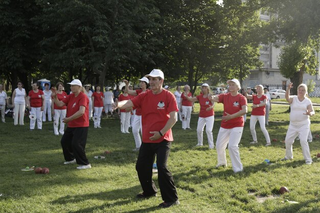 Dnepr Ukraine 06212021 Group of elderly people doing health and fitness gymnastics in the park