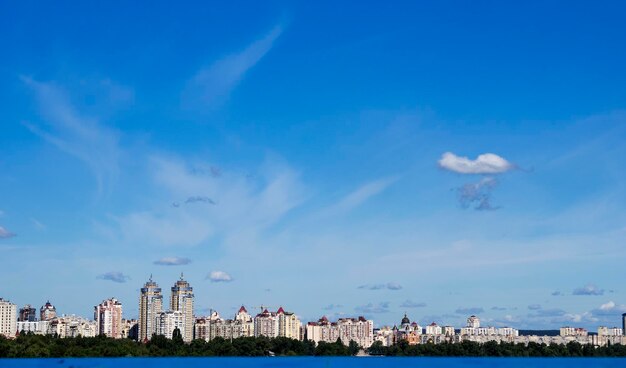 Dnieper river by buildings against cloudy sky