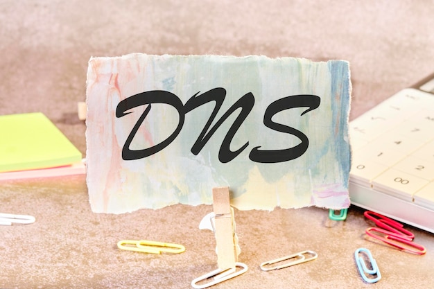Foto testo dns domain name server su un pezzo di carta sul tavolo con una molletta fissata