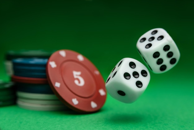 Dobbelstenen en pokerfiches close-up op een groene achtergrond