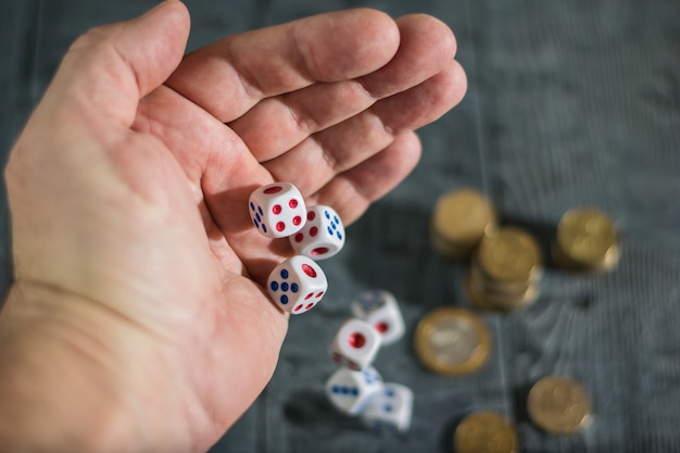 Dobbelstenen gooien met linkerhand mannen op de tafel met geld.