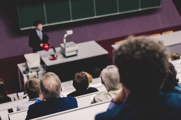 Docent aan de universiteit Zorgexpert geeft een lezing met hoogleraren van de medische faculteit Deelnemers luisteren naar college en maken aantekeningen