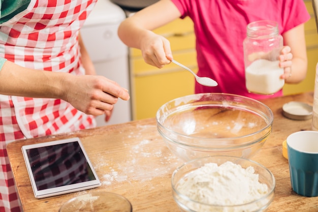 Dochter en moeder die pizzadeeg maken