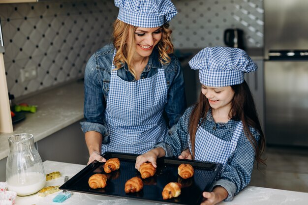 Dochter en moeder gebakken croissants. Familie concept