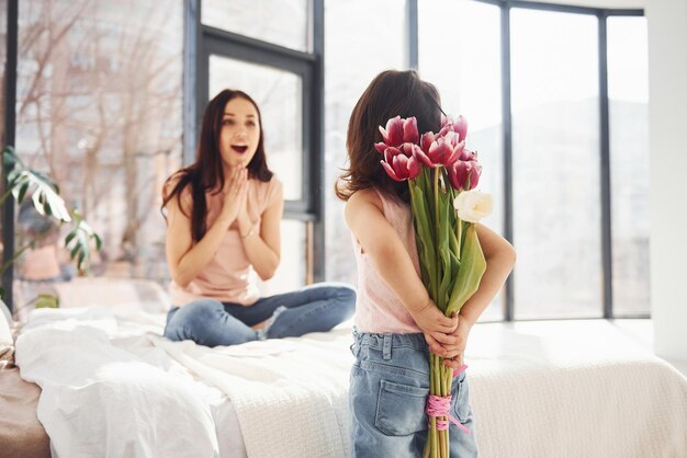 Dochter feliciteert moeder met vakantie en geeft boeket bloemen