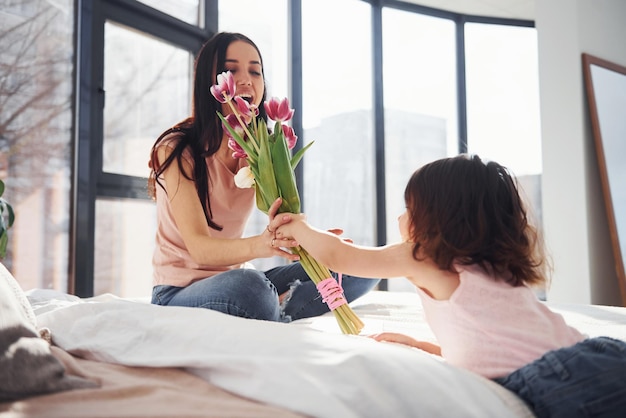 Dochter feliciteert moeder met vakantie en geeft boeket bloemen