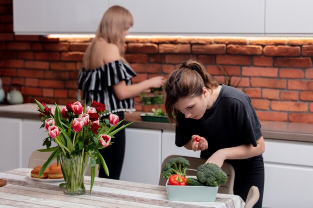 Dochter helpt moeder met koken voor het avondeten in de keuken