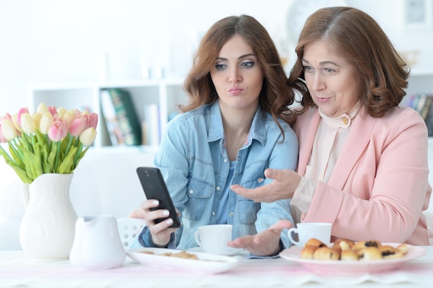 Dochter leert een bejaarde moeder om een mobiele telefoon te gebruiken