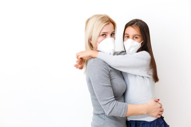 Dochter met moeder in chirurgische maskers. Gezin met kinderen in gezichtsmasker ffp1. Virus- en ziektebescherming in een openbare drukke plaats. Moeder en dochter slaapkamer dragen beschermingsmasker, gezondheidszorg