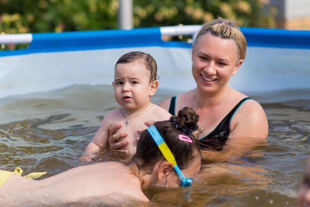 Foto dochters en moederfamilie zwemmen in zwembad op zomervakantie