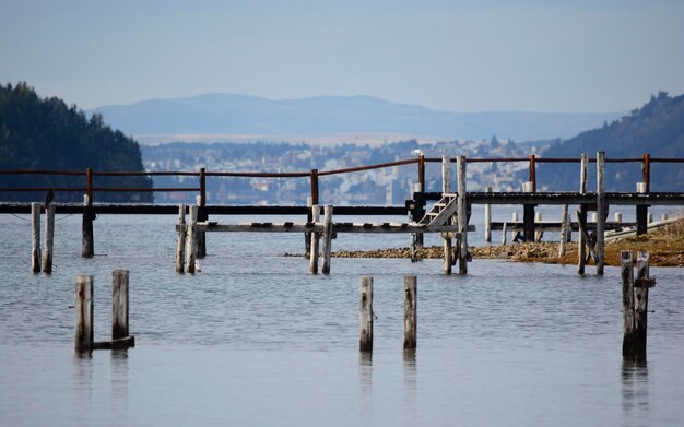 dock in the middle of a lake in bariloche with views of the city in the background