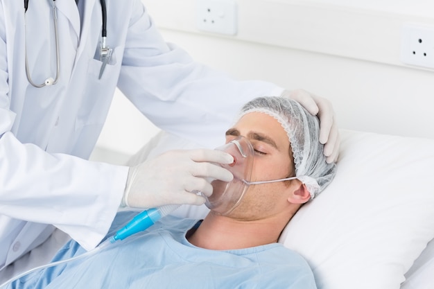 Doctor adjusting oxygen mask on patient