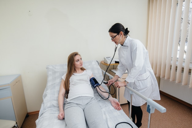 The doctor advises and serves a young pregnant girl in a medical clinic. Medical examination