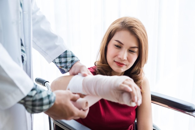 Foto un medico che applica una benda alla mano di una donna in ospedale