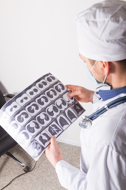 Doctor at appointment inspects and examines ct scan of chest and abdominal cavity. Concept photo on diagnosis of diseases in pulmonology, lung pathology, inflammatory diseases of bronchi, tuberculosis