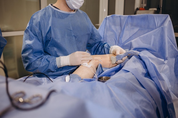 Doctor and an assistant in the operating room for surgical venous vascular surgery clinic