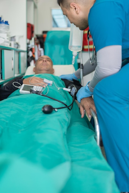 Photo doctor assisting a conscious patient stretched out on a stretcher in an ambulance