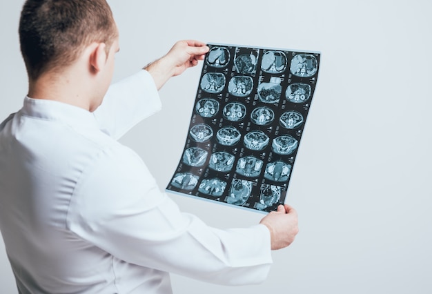 Doctor attentively examines the MRI scan of the patient.