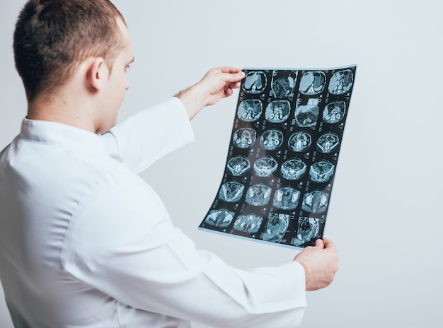doctor attentively examines the mri scan of the patient.