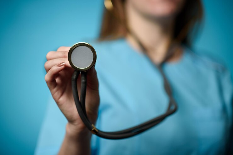 A doctor on a blue background holds a stethophonendoscope Closeup