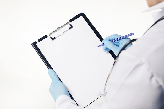 흰색에 고립 된 빈 빈 종이와 의료 클립보드를 들고 파란색 장갑에 의사