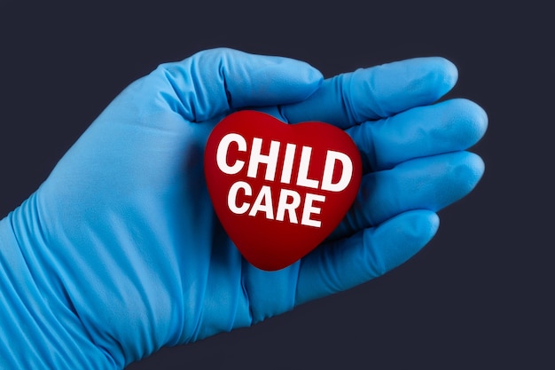 Photo doctor in blue gloves holds a heart with text child care, concept