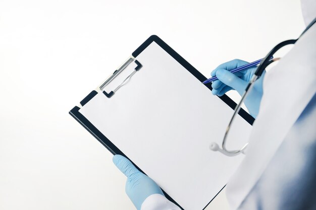 Doctor in blue latex gloves holding medical clipboard with empty blank sheet Isolated on white