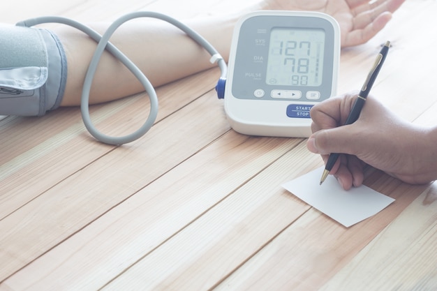 Doctor cardiologist measuring blood pressure of male patient. Health concept