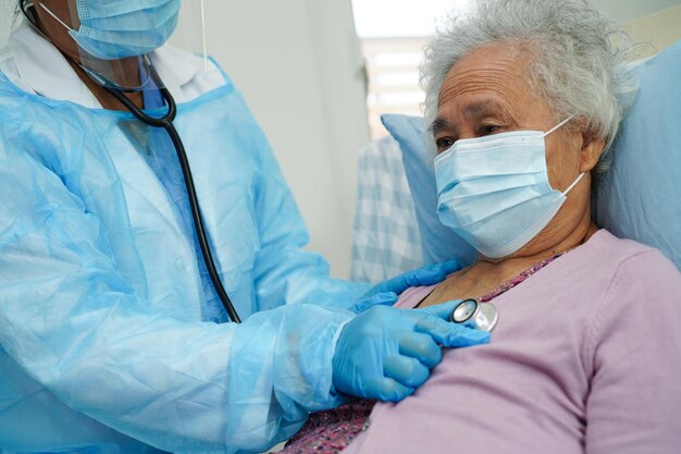 Doctor check Asian elder senior woman patient wearing a mask for protect covid coronavirus