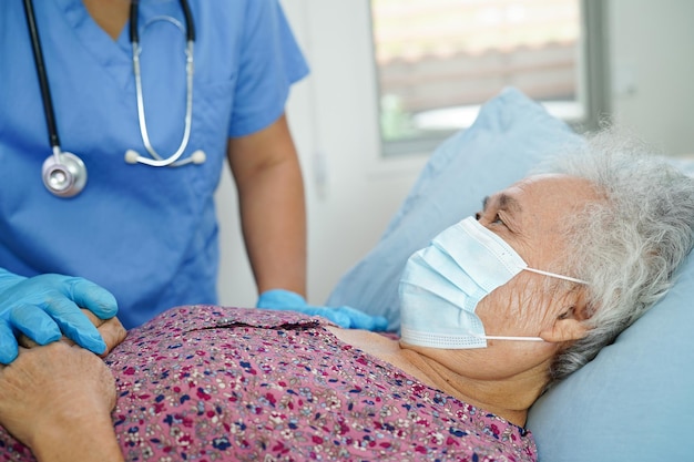 Doctor check Asian elder senior woman patient wearing a mask for protect covid coronavirus