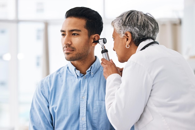 Doctor check patient ear consultation and healthcare people at hospital with otolaryngology specialist Man and senior physician woman with otoscope test for hearing problem and health insurance