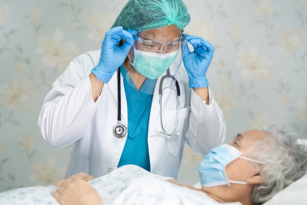 Doctor checking Asian senior woman patient for protect Covid-19 Coronavirus.