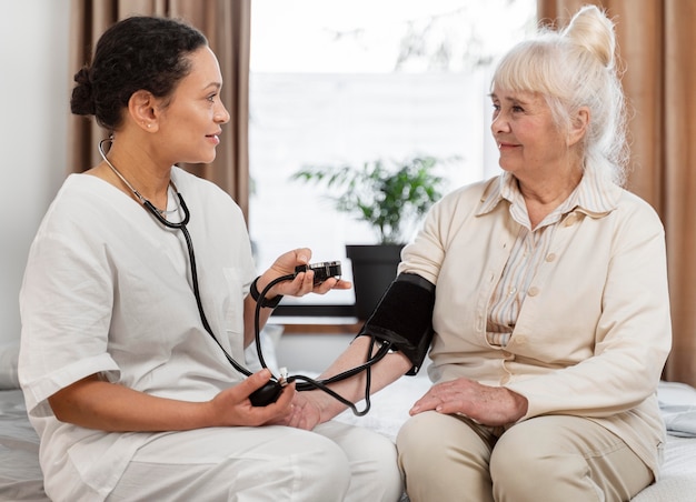 Photo doctor checking the blood pressure of her patient