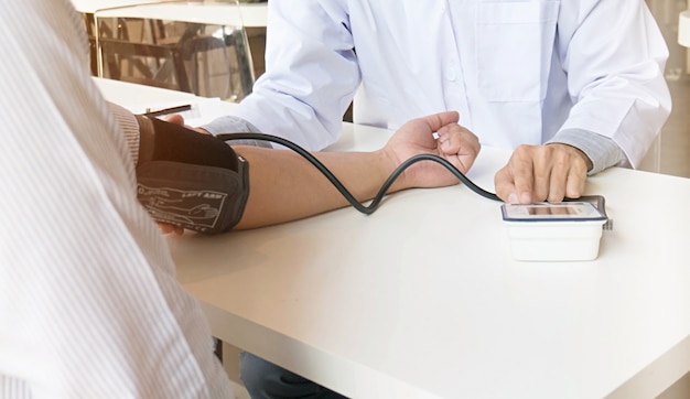 Doctor checking old woman patient arterial blood pressure. Health care